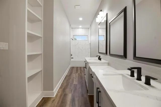 an empty room with a hardwood and windows