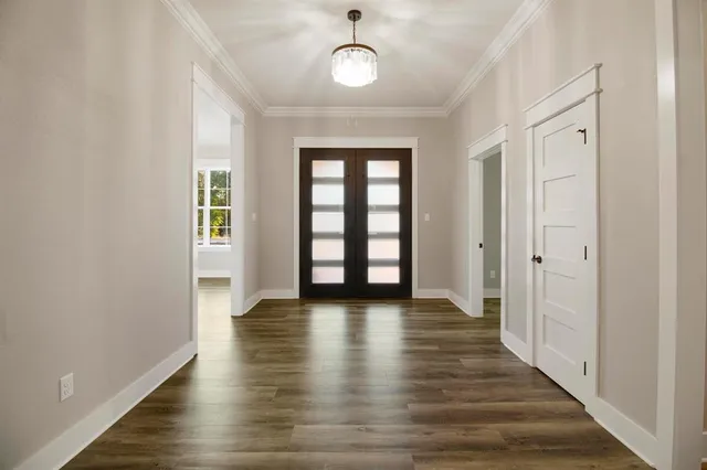 a view of an empty room with window and wooden floor