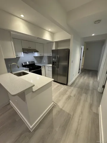 a kitchen with stainless steel appliances kitchen island granite countertop a refrigerator and a sink