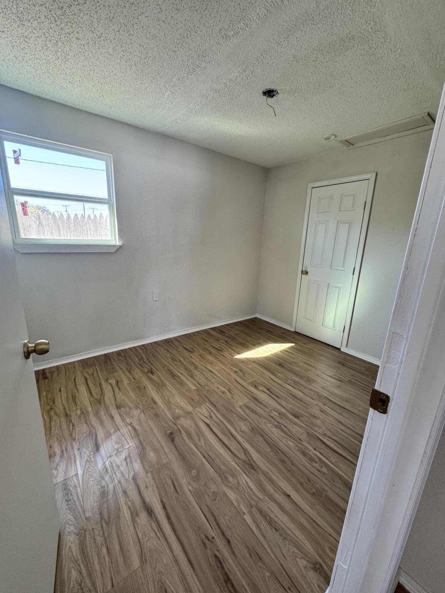 4512 Lehigh Street, Unit B Lubbock, TX 79416 - Photo 3 of 6 a view of an empty room with wooden floor and closet