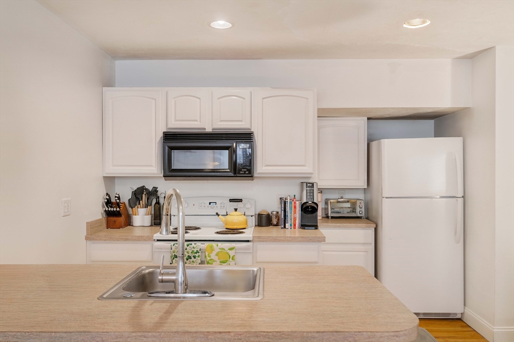 188 North Street, Unit 22 Boston, MA 02113 - Photo 12 of 18 a kitchen with a sink a microwave and cabinets