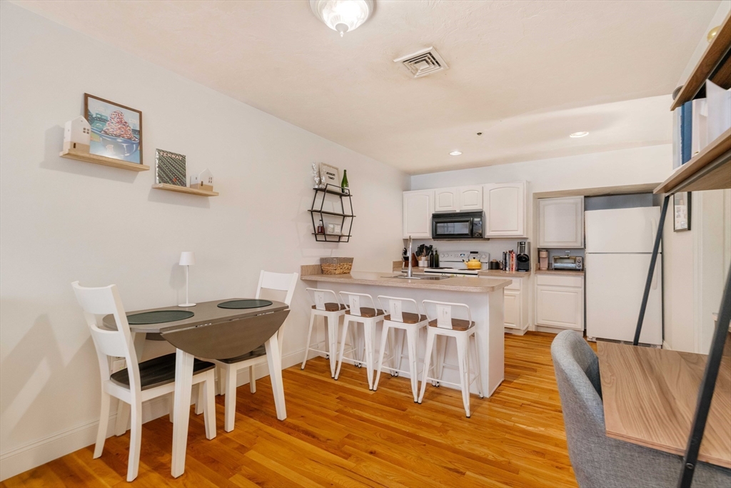 188 North Street, Unit 22 Boston, MA 02113 - Photo 9 of 18 a kitchen with stainless steel appliances granite countertop a white cabinets and a stove top oven