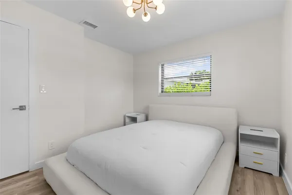 a bedroom with a bed and a chandelier