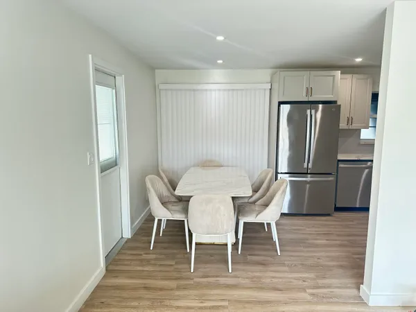 a kitchen with granite countertop a refrigerator and wooden floor