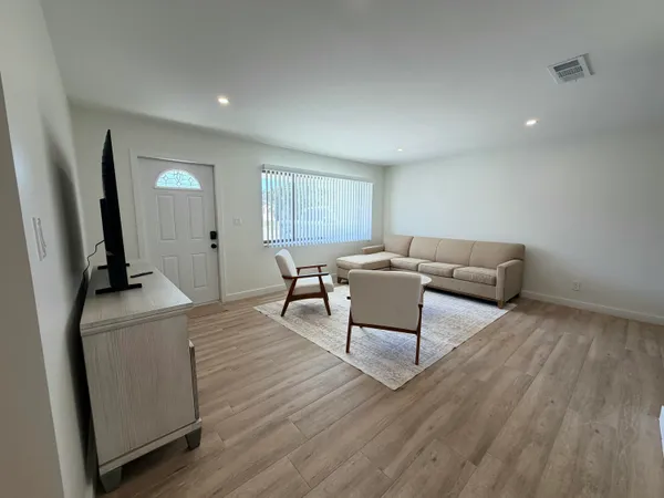a living room with furniture and a wooden floor