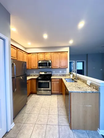a kitchen with stainless steel appliances granite countertop a stove a sink and a refrigerator