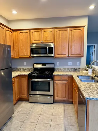 a kitchen with granite countertop a stove top oven microwave and cabinets