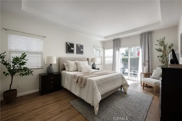 a bedroom with a large bed and a potted plant