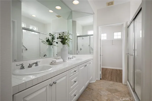 a spacious bathroom with double sink and shower