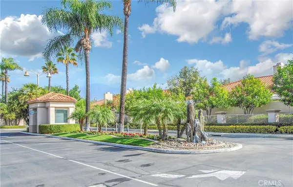 a front view of a house with a yard and palm trees