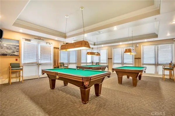 a room with pool table and windows