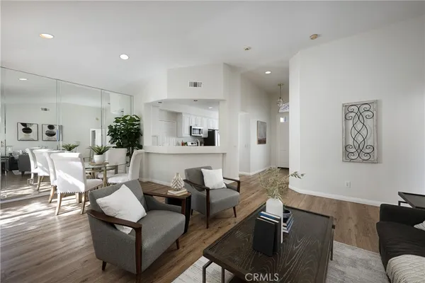 a living room with furniture and a view of kitchen