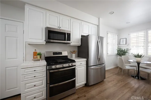 a kitchen with granite countertop a refrigerator stove and microwave