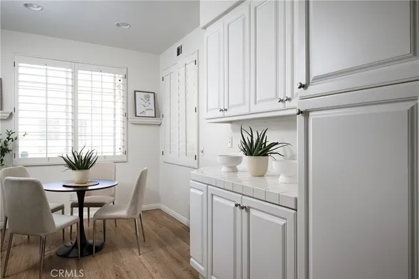 a kitchen with stainless steel appliances a table and chairs in it
