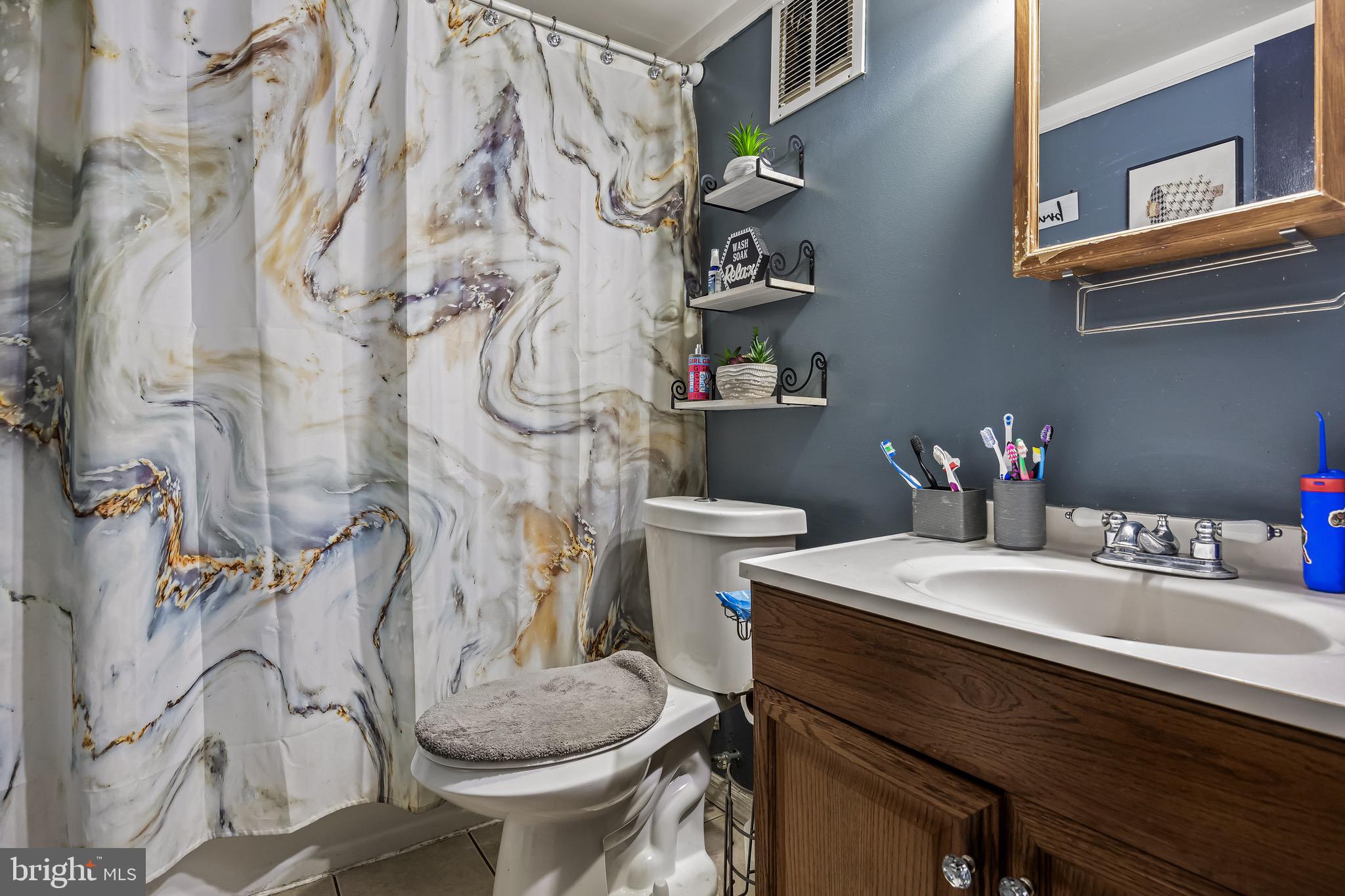 1294 Cooper Street, Unit E13 Edgewater Park, NJ 08010 - Photo 11 of 15 a bathroom with a sink and mirror with toilet