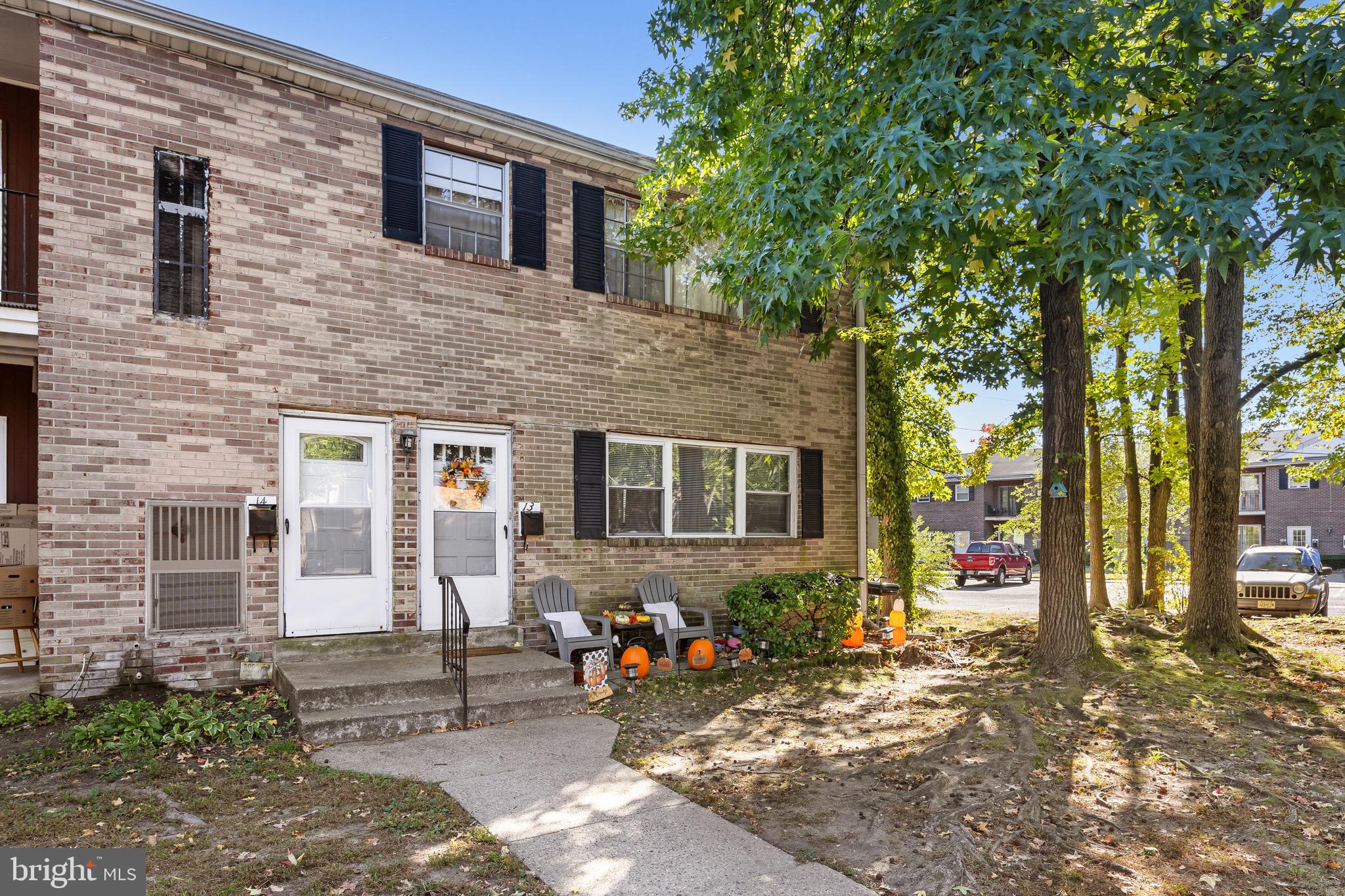 1294 Cooper Street, Unit E13 Edgewater Park, NJ 08010 - Photo 2 of 15 a view of a house with large windows and a tree
