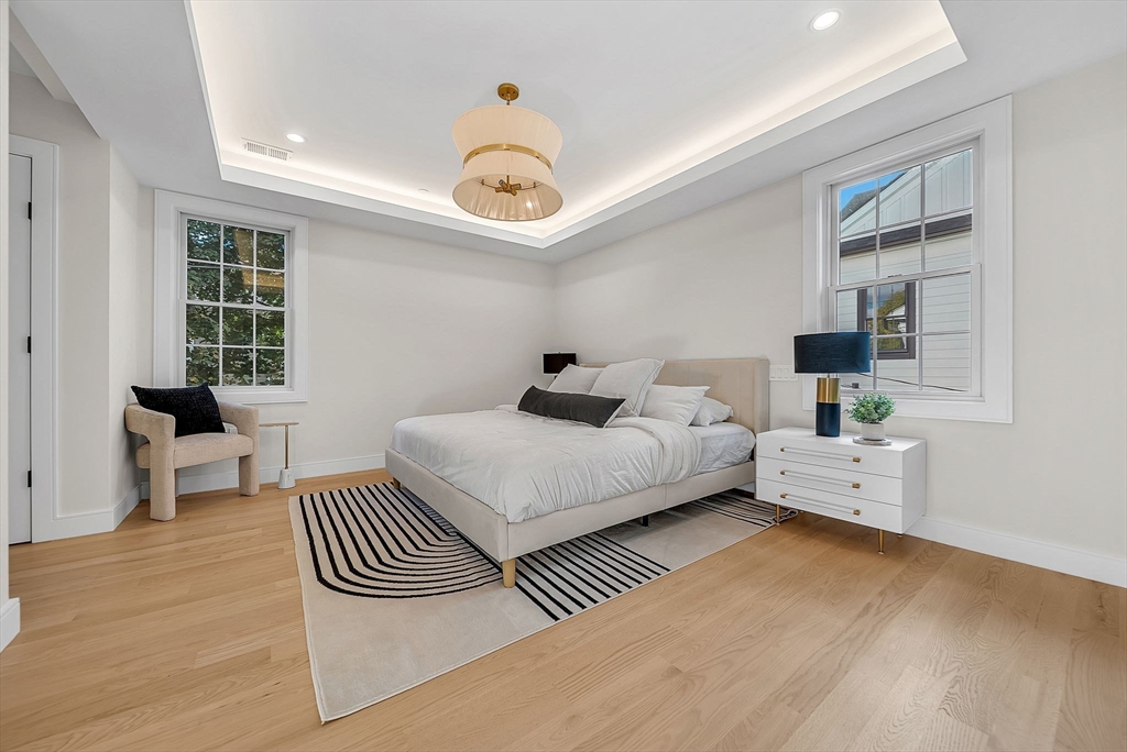 284 Nevada Street, Unit 284 Newton, MA 02460 - Photo 14 of 29 a bedroom with a bed and wooden floor