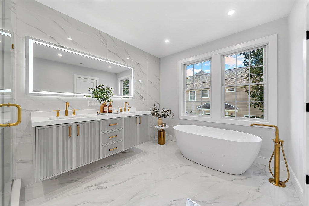 284 Nevada Street, Unit 284 Newton, MA 02460 - Photo 15 of 29 a spacious bathroom with a double vanity sink a mirror a bathtub and next to a window