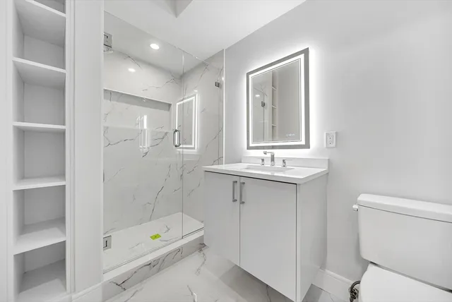 a bathroom with a sink a toilet and shower