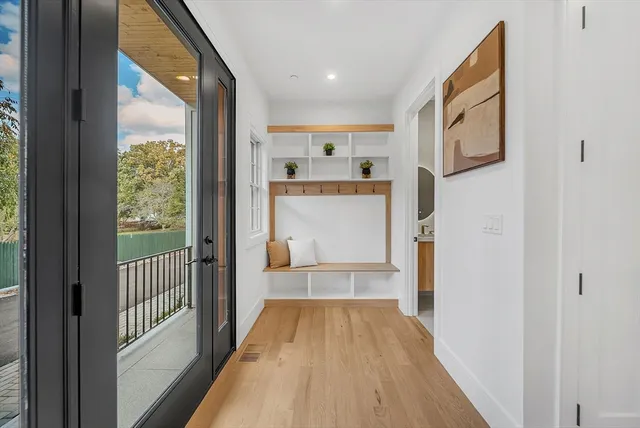 a view of a hallway with wooden floor and a living room