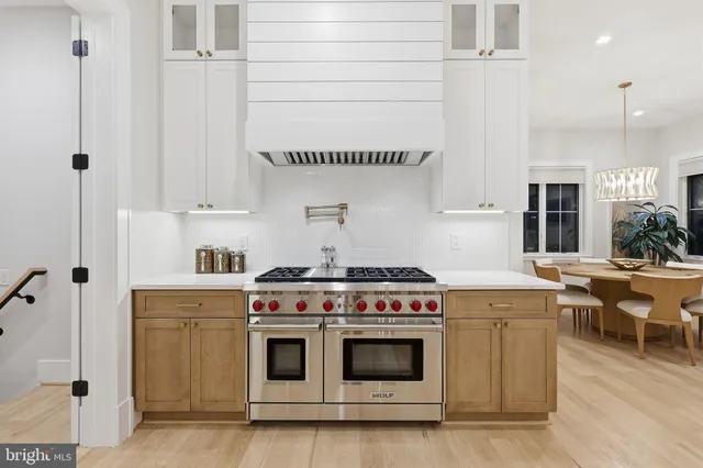 a kitchen with a stove and white cabinets