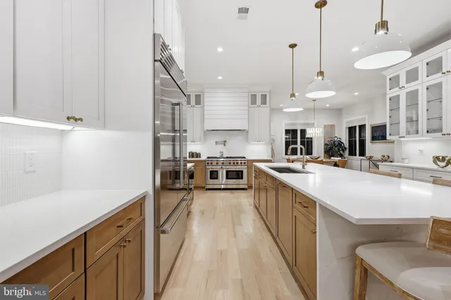 a large kitchen with kitchen island a large counter space a sink appliances and cabinets