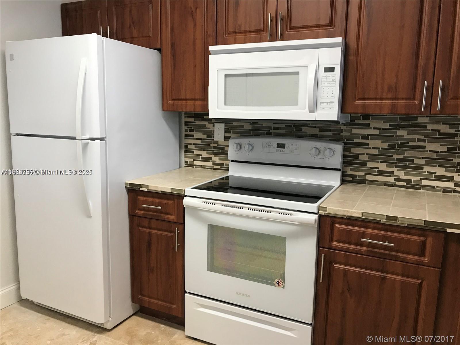 10288 Northwest 9th St Circle, Unit 205 Miami, FL 33172 - Photo 6 of 11 a kitchen with appliances and cabinets
