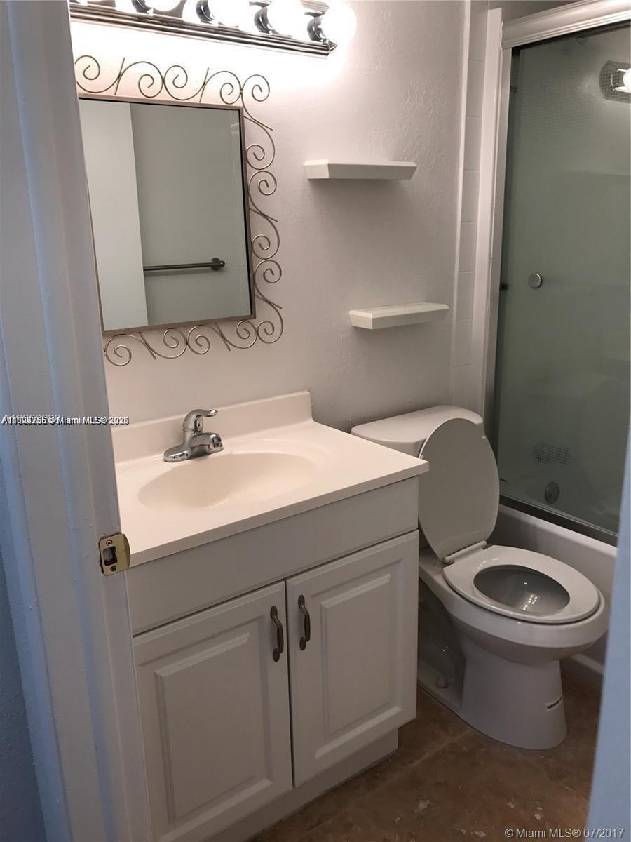 10288 Northwest 9th St Circle, Unit 205 Miami, FL 33172 - Photo 10 of 11 a bathroom with a toilet sink and mirror
