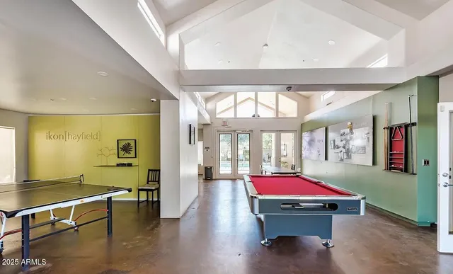 a living room with furniture pool table and a window