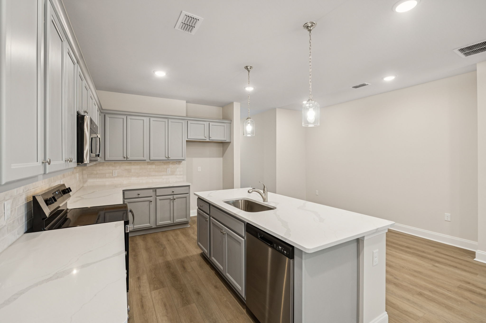 8152 Rocky Fork Almaville Road Smyrna, TN 37167 - Photo 21 of 43 a kitchen that has a sink a microwave oven a stove and white cabinets with wooden floor