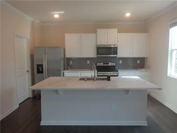 a kitchen with kitchen island stainless steel appliances a sink stove and refrigerator