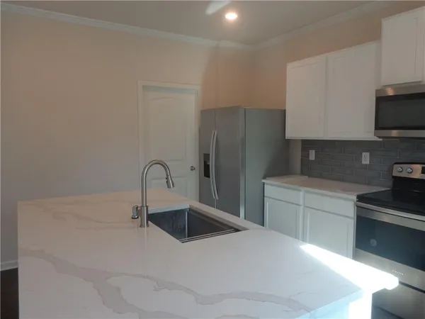 a kitchen with a refrigerator sink and white cabinets