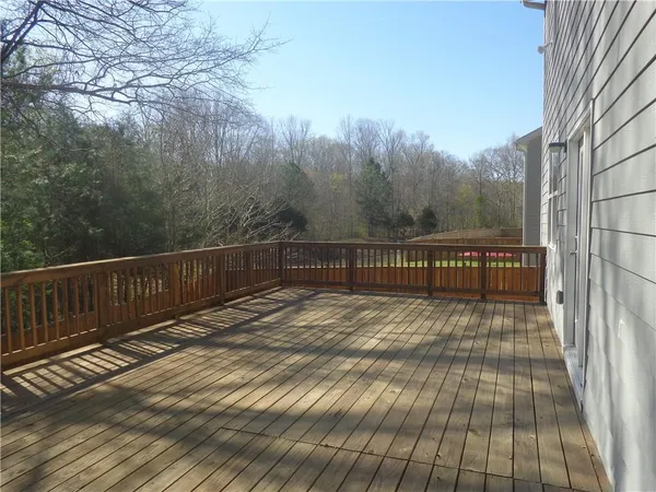 a view of balcony with wooden floor and fence