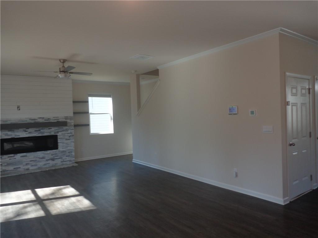132 Russell Road Pendergrass, GA 30567 - Photo 10 of 50 an empty room with wooden floor fireplace and windows