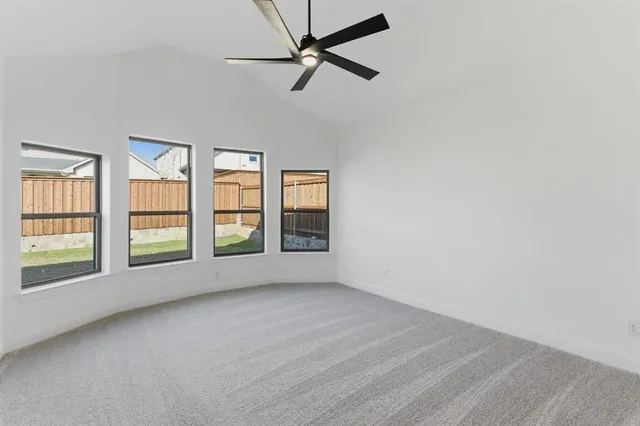 an empty room with windows and ceiling fan