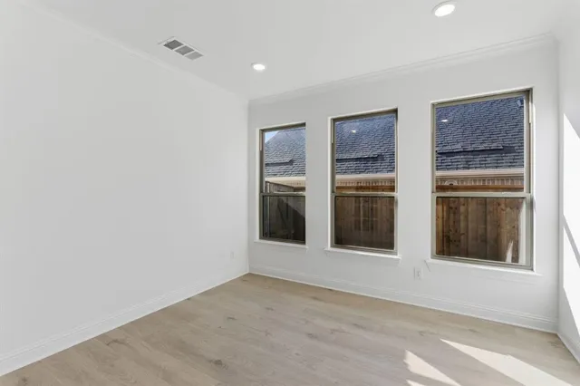 a view of an empty room with a window and cabinet