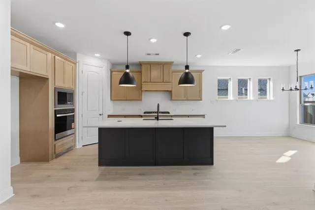 a large kitchen with kitchen island a sink stainless steel appliances and cabinets