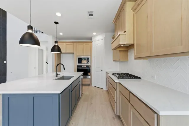a kitchen with stainless steel appliances granite countertop a sink a stove and a refrigerator