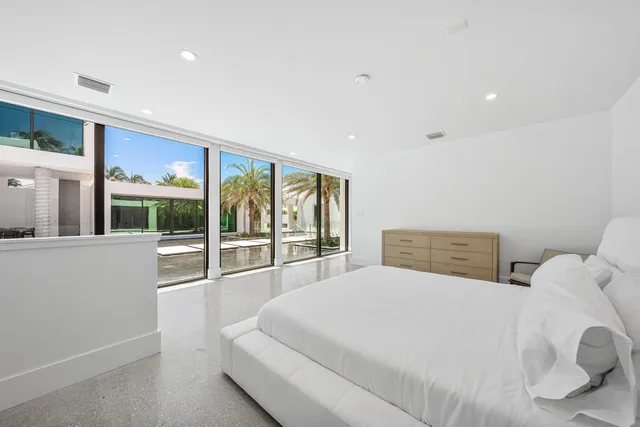 a spacious bedroom with a large bed and a large window