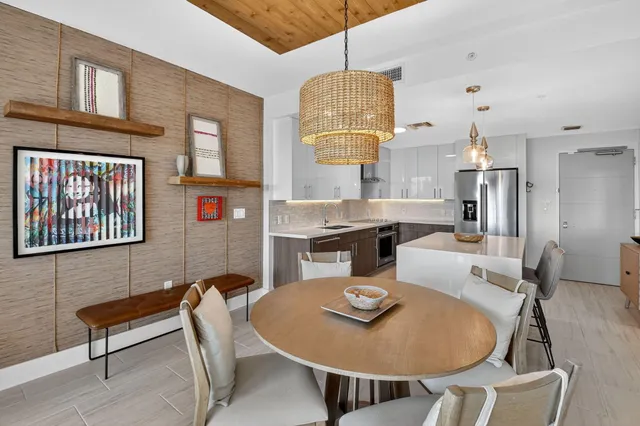 a dining room with furniture a chandelier and wooden floor