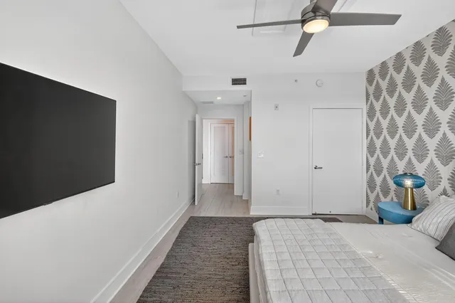 a bedroom with a bed and a chandelier fan