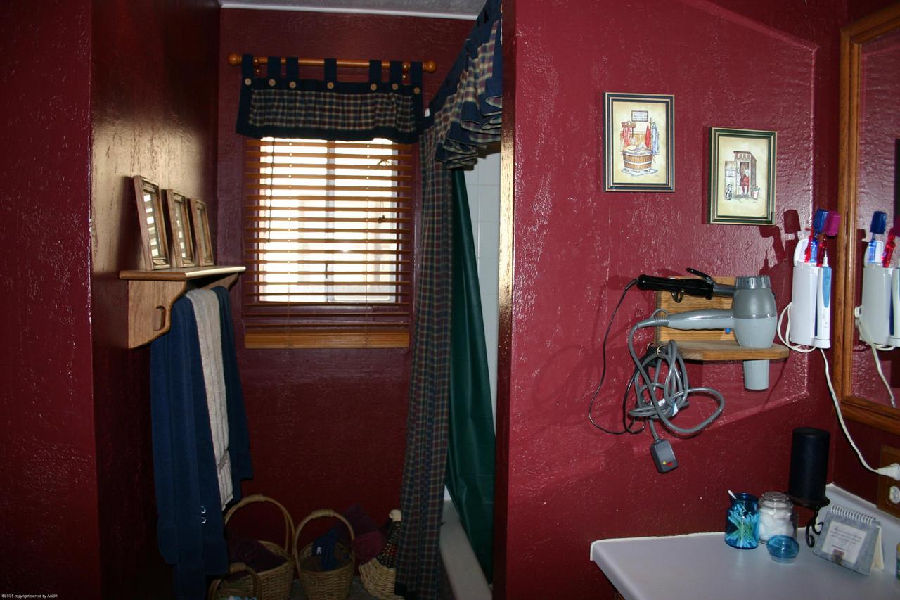 4618 South Rusk Street Amarillo, TX 79110 - Photo 7 of 10 a bathroom with a sink and a mirror