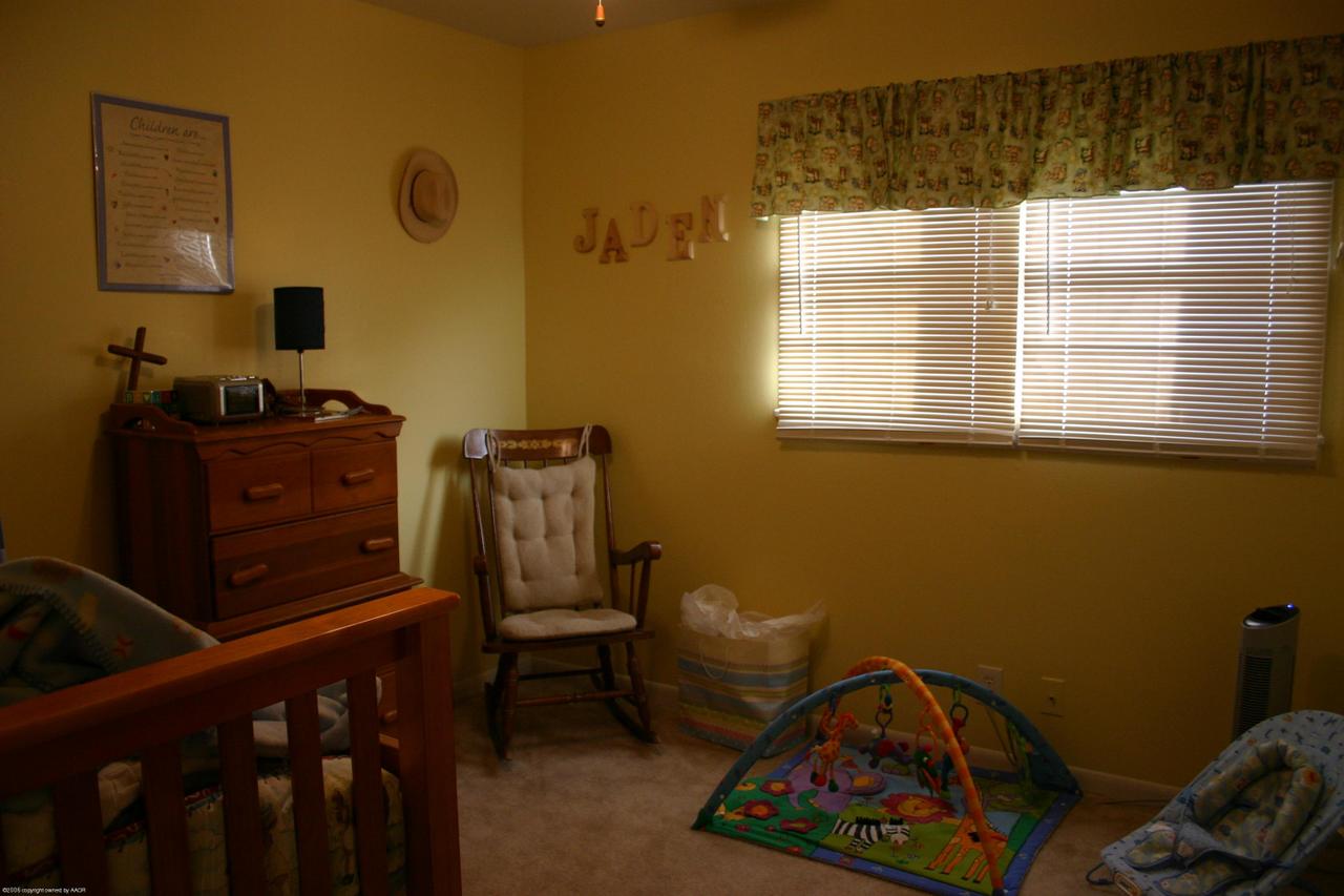 4618 South Rusk Street Amarillo, TX 79110 - Photo 8 of 10 a bedroom with a bed and wooden floor