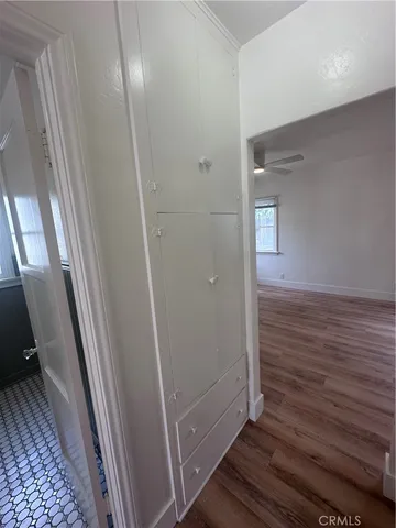 a view of an empty room with a window and wooden floor