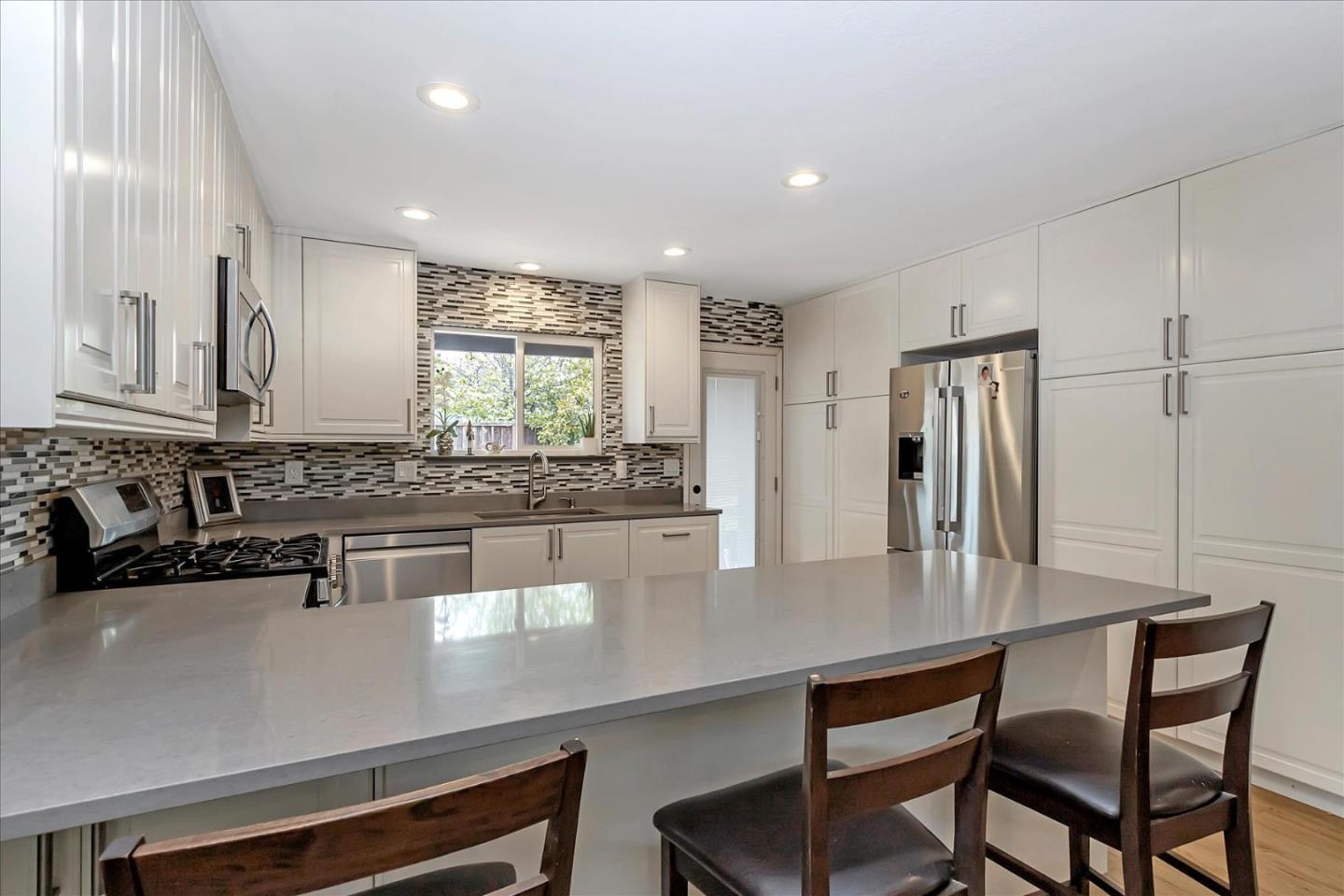 637 Escuela Place Milpitas, CA 95035 - Photo 12 of 49 a kitchen with stainless steel appliances a dining table chairs and granite counter tops