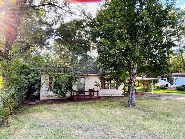 a view of a house with garden and a tree