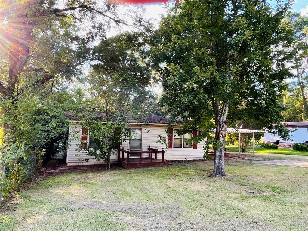 a view of a house with garden and a tree