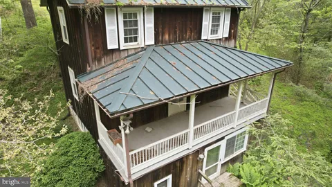 a view of backyard with deck and wooden stairs