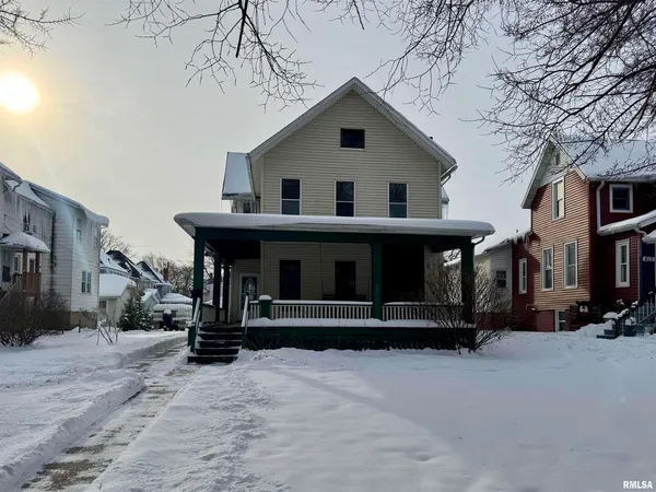 a view of a house with a yard covered in snow
