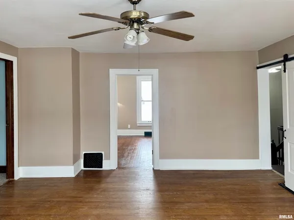 a view of empty room with wooden floor